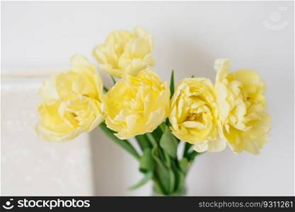 Bouquet of yellow tulips in a vase. A gift for Women’s Day of yellow tulip flowers. Beautiful yellow flowers for the holiday