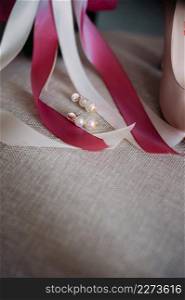 Bouquet, shoes and jewelry of the bride on the chair.. Womens elements of the wedding wardrobe in anticipation of the weddi