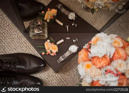 Bouquet, shoes, watches and other elements of the wardrobe for the wedding.. The elements of the bride and grooms wardrobe are on the table before