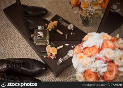 Bouquet, shoes, watches and other elements of the wardrobe for the wedding.. The elements of the bride and grooms wardrobe are on the table before