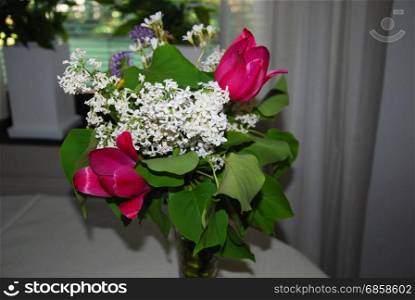 Bouquet with colorful summer flowers in a vase on a table indoors