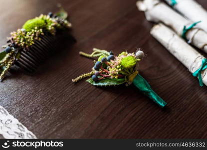 boutonniere made of cotton lying on a brown table with lace, scrolls of old parchment