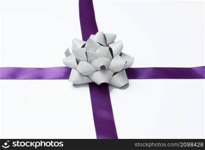bow and purple silk ribbon on a white background, design element for gift decor