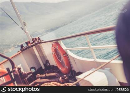 Bow of a boat with safety buoy on a boat tour. Blue water and mountain range, Lago di Garda, Italy