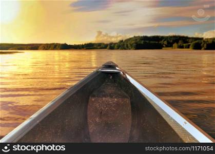 Bow of a canoe navigating the water in the twilight