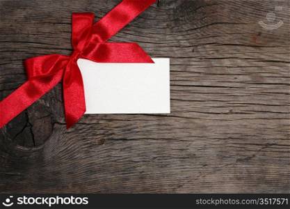 Bow with blank of card on grunge wood