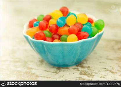 Bowl filled with jelly beans colors on a wooden table