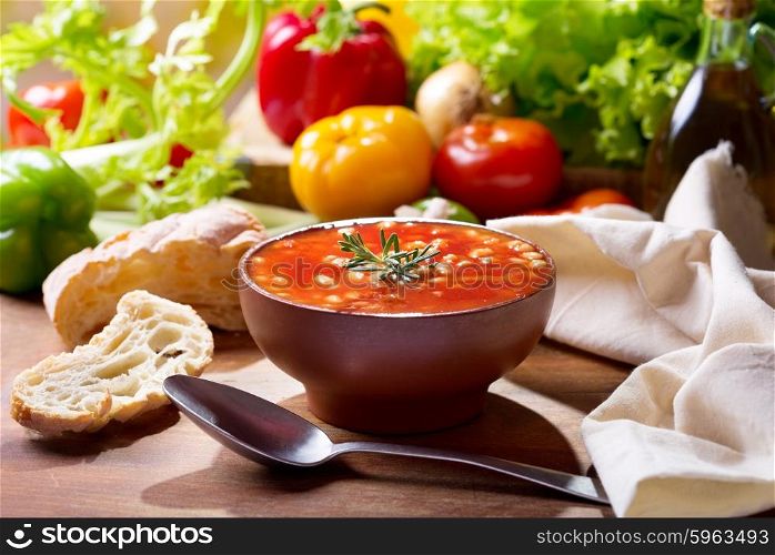 bowl of bean soup with rosemary on wooden table