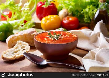 bowl of bean soup with rosemary on wooden table