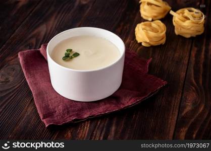 Bowl of bechamel sauce with tagliatelle pasta