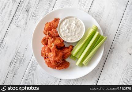 Bowl of buffalo wings with blue cheese dip on the wooden backround