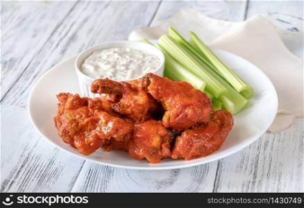 Bowl of buffalo wings with blue cheese dip on the wooden backround