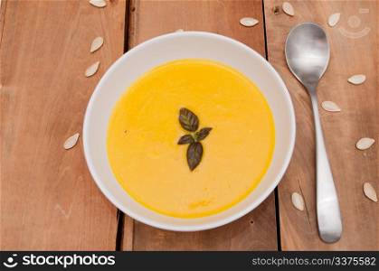 Bowl of Butternut Squash Soup and Spoon on Old Wooden Table