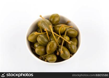 Bowl of canned capers on a white background