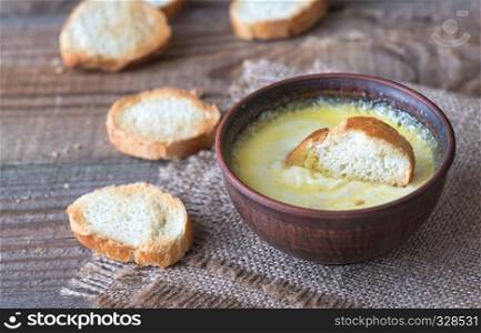 Bowl of cheese dip with toasts