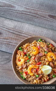 Bowl of chicken and chorizo paella with lemon wedge