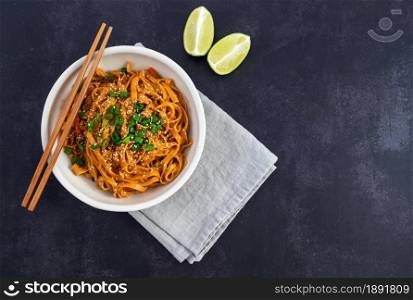 Bowl of chili noodles with mushrooms, red bell pepper and green onion. Asian food. Top view, copy space