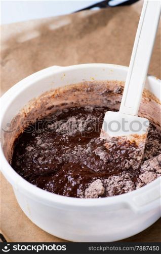 Bowl of chocolate batter being stirred around, selective focus. The process of making chocolate batter.