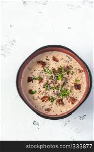 Bowl of clam chowder garnished with chopped bacon and fresh parsley