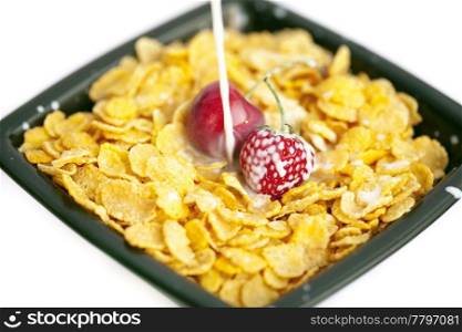 bowl of cornflakes milk cherry and strawberry isolated on white