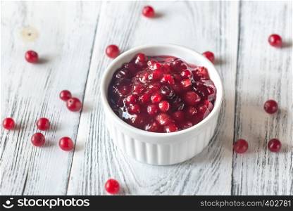Bowl of cranberry sauce on the wooden background