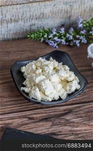 Bowl of cream cheese on wooden background.