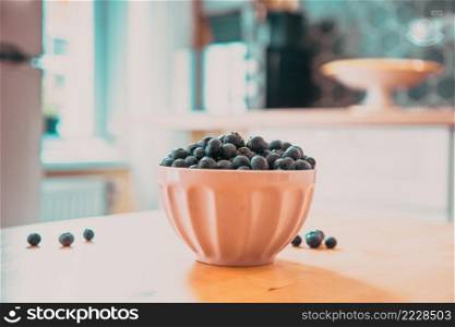 bowl of fresh blueberries on rustic kitchen table