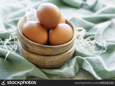 Bowl of fresh  brown eggs on concrete background