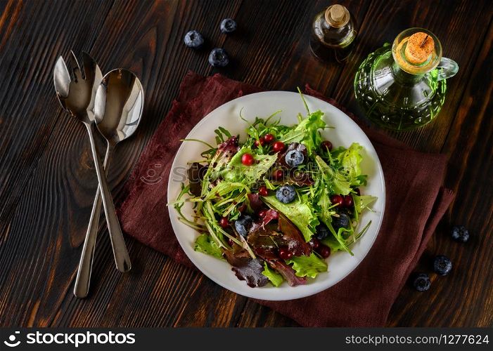 Bowl of fresh lettuce with berries and balsamic sauce