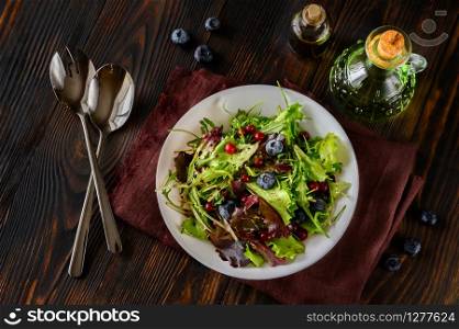 Bowl of fresh lettuce with berries and balsamic sauce