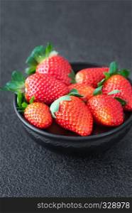 Bowl of fresh strawberries on the wooden table