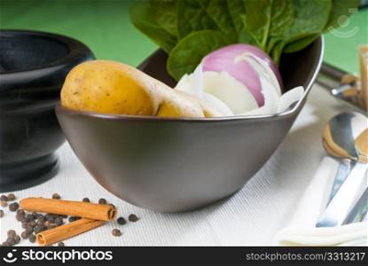 bowl of fresh vegetable with spice and mortar beside,basic ingredients for a soup recipe