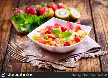 bowl of fruit salad on wooden table