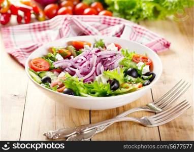 bowl of greek salad on wooden table