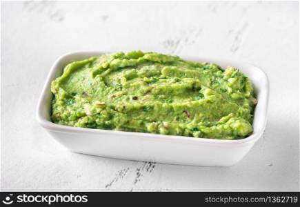 Bowl of guacamole on white background