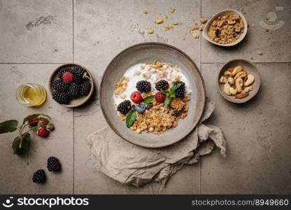 Bowl of homemade granola with yogurt and fresh berries on gray background from top view. Bowl of homemade granola