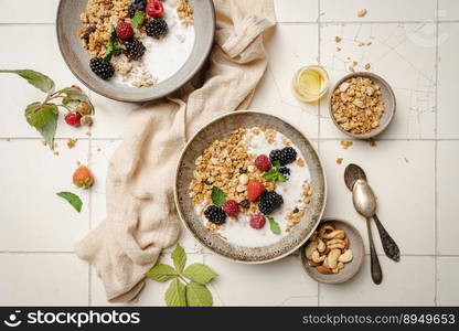 Bowl of homemade granola with yogurt and fresh berries on white background from top view. Bowl of homemade granola