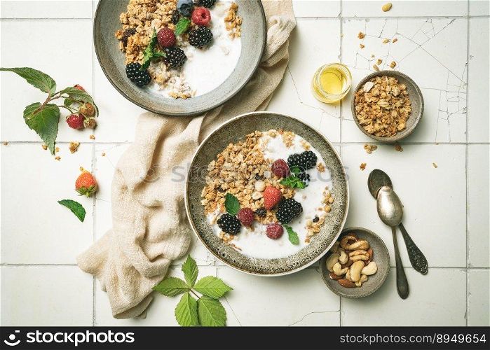Bowl of homemade granola with yogurt and fresh berries on white background from top view. Bowl of homemade granola