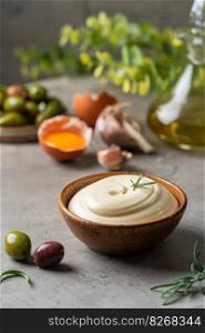 Bowl of Homemade mayonnaise sauce with olives, ingredients and herbs for cooking. Homemade mayonnaise sauce