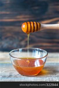 Bowl of honey on the dark wooden background