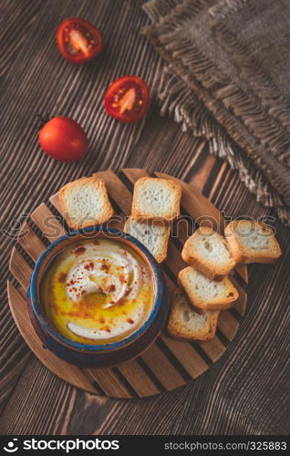 Bowl of hummus with cherry tomatoes and toasts