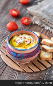 Bowl of hummus with cherry tomatoes and toasts
