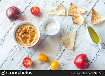 Bowl of hummus with fresh vegetables and tortilla chips