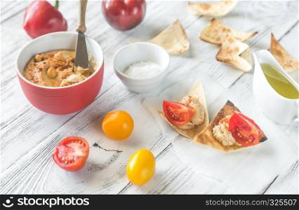 Bowl of hummus with fresh vegetables and tortilla chips