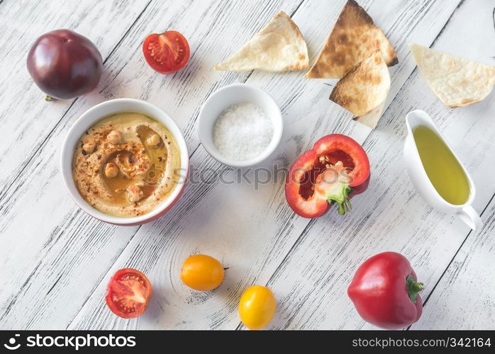 Bowl of hummus with fresh vegetables and tortilla chips