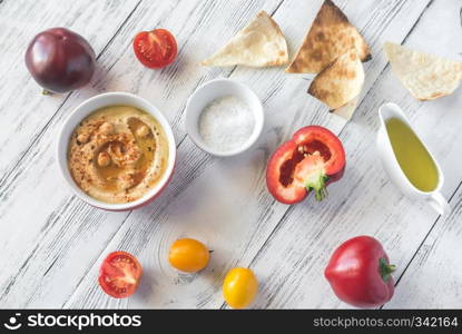 Bowl of hummus with fresh vegetables and tortilla chips