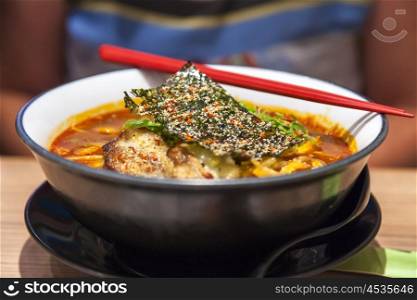 Bowl of Japanese pork ramen noodles with chopsticks in an Asian restaurant
