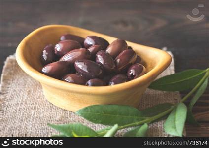 Bowl of kalamata olives on the wooden background