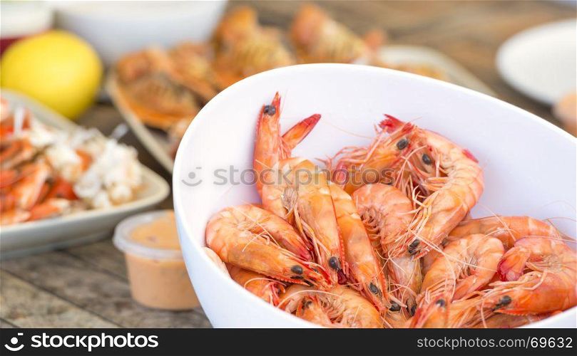 Bowl of large fresh prawns with other seafood behind