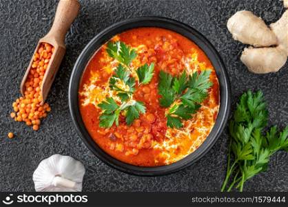 Bowl of lentil tomato and coconut soup flat lay